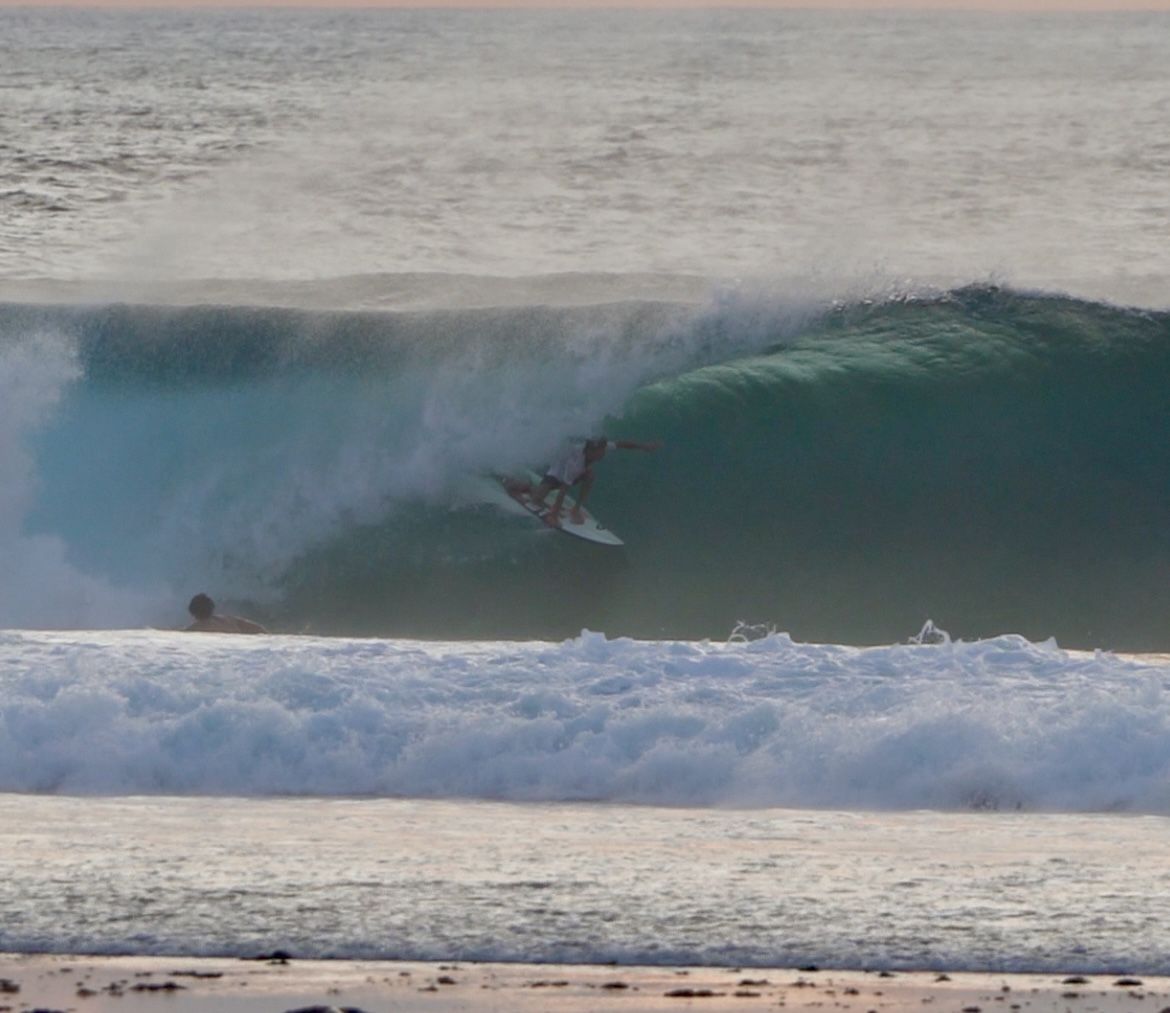 Surfista dentro de un tubo de agua celeste